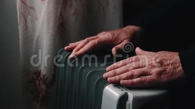 一位老人把手暖和在电热器上.